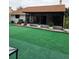 Home backyard featuring artificial grass and a covered patio at 8718 Lindenhurst Pl, Tampa, FL 33634