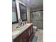 This bathroom has granite counters, dual sinks, and a glass enclosed shower, offering space and luxury at 8718 Lindenhurst Pl, Tampa, FL 33634