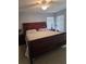 This main bedroom features tile floors, neutral colors, and plenty of natural light from two large windows at 8718 Lindenhurst Pl, Tampa, FL 33634