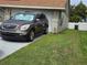 Exterior of the home featuring a car in the driveway and green grass at 8718 Lindenhurst Pl, Tampa, FL 33634