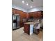 Modern kitchen with granite countertops, stainless steel appliances, and custom cabinetry at 8718 Lindenhurst Pl, Tampa, FL 33634