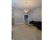 Open-concept living room with neutral tile floors and decorative chandelier at 8718 Lindenhurst Pl, Tampa, FL 33634
