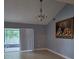 Open living space with tile floors, large sliding glass door and fruit painting at 8718 Lindenhurst Pl, Tampa, FL 33634