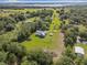 An aerial view of a well-maintained home with an expansive yard and mature trees in a tranquil setting at 8843 Kenton Rd, Wesley Chapel, FL 33545