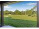 Enjoy the serene backyard view from the covered patio, offering ample green space and privacy at 8843 Kenton Rd, Wesley Chapel, FL 33545