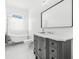 Bright bathroom features a claw foot tub and gray vanity with marble countertops, offering a modern yet classic look at 8843 Kenton Rd, Wesley Chapel, FL 33545