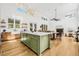 Bright, open kitchen boasts white countertops, farmhouse sink, and an island with a light green base at 8843 Kenton Rd, Wesley Chapel, FL 33545