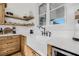 Farmhouse sink with white countertops and wooden shelves and cabinets at 8843 Kenton Rd, Wesley Chapel, FL 33545