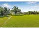 Expansive green field with a gravel path, showcasing the natural beauty and open space of the property at 8843 Kenton Rd, Wesley Chapel, FL 33545