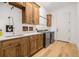 Well-equipped laundry room with wooden cabinets, sink, and stainless steel washer and dryer at 8843 Kenton Rd, Wesley Chapel, FL 33545