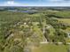 Aerial view outlining the property lines of a vast estate with scattered trees and multiple structures at 8843 Kenton Rd, Wesley Chapel, FL 33545