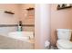 Relaxing bathroom with a large oval bathtub surrounded by tile, and a toilet at 915 Windton Oak Dr, Ruskin, FL 33570