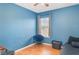 Blue bedroom with a hardwood floor, a large window, and simple furnishings at 915 Windton Oak Dr, Ruskin, FL 33570