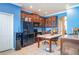 Cozy kitchen with dark wood cabinetry, black appliances, and a dining table with tiled floor at 915 Windton Oak Dr, Ruskin, FL 33570