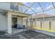 Enclosed screened patio overlooking a backyard and featuring a ceiling fan at 915 Windton Oak Dr, Ruskin, FL 33570
