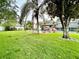 Spacious backyard with mature trees, lush grass, and a refreshing pool area with seating at 945 College Hill Dr, Clearwater, FL 33765