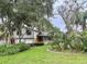 Charming two-story home featuring lush landscaping, mature trees, and a well-manicured lawn at 945 College Hill Dr, Clearwater, FL 33765