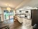 Open kitchen with white cabinets, stainless steel appliances, granite counters, and sliding doors to pool area at 945 College Hill Dr, Clearwater, FL 33765