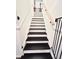 Stairway with black steps, white risers, wood handrail, and guitar decor at top landing at 945 College Hill Dr, Clearwater, FL 33765