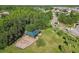 This aerial view showcases a playground with a green shade cover near mature trees and residential streets at 1032 Jacob Way, Odessa, FL 33556