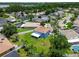 Aerial view showcases the home's backyard, white fence, mature trees, and its proximity to local parks and a lake at 1032 Jacob Way, Odessa, FL 33556