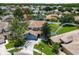 Aerial view of a blue two-story home with a well-manicured lawn, mature trees, and a lovely neighborhood at 1032 Jacob Way, Odessa, FL 33556