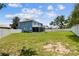 Large backyard showcasing lush green grass, a screened-in patio, and a white fence, offering privacy and space for outdoor fun at 1032 Jacob Way, Odessa, FL 33556