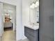 Modern bathroom vanity with gray cabinets, white countertop, and updated lighting fixture; doorway to living room at 1032 Jacob Way, Odessa, FL 33556