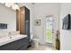 Bathroom featuring a stylish vanity, toilet, and access to the outdoors through a glass door for natural light at 1032 Jacob Way, Odessa, FL 33556