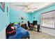 Bright bedroom with a cozy bed, desk, and modern ceiling fan at 1032 Jacob Way, Odessa, FL 33556