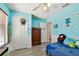 Bright bedroom with blue walls, white trim, a ceiling fan, and laminate flooring; kid-friendly decor at 1032 Jacob Way, Odessa, FL 33556