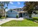 Charming two-story home featuring blue exterior, well-manicured lawn, and a two-car garage at 1032 Jacob Way, Odessa, FL 33556