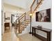 Bright foyer featuring wood stairs with modern metal railings and neutral tile floors that offers view to the dining area at 1032 Jacob Way, Odessa, FL 33556