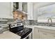 Close-up of a modern kitchen with stainless steel appliances, white cabinetry and stylish backsplash at 1032 Jacob Way, Odessa, FL 33556