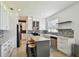 Modern kitchen featuring white cabinets, stylish backsplash, a central island, and stainless steel appliances at 1032 Jacob Way, Odessa, FL 33556