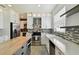 Bright kitchen with white cabinets, butcher block island, stainless steel appliances, and chic backsplash at 1032 Jacob Way, Odessa, FL 33556