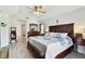 Spacious main bedroom featuring wood-look floors, ceiling fan, king-size bed, and coordinating furniture at 1032 Jacob Way, Odessa, FL 33556