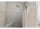 Walk-in shower with natural stone tile, a built-in bench, and a shower head; modern and inviting design at 1032 Jacob Way, Odessa, FL 33556
