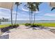 Spacious patio with palm trees overlooking tranquil waterfront and blue skies at 11055 7Th E St, Treasure Island, FL 33706