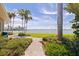 A paved walkway leading to the waterfront backyard with manicured landscaping at 11055 7Th E St, Treasure Island, FL 33706