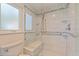 Updated bathroom with glass shower, shower bench, and grab bar for accessibility at 11055 7Th E St, Treasure Island, FL 33706