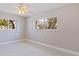 Bright bedroom with white tile flooring, a ceiling fan, and large windows offering natural light at 11055 7Th E St, Treasure Island, FL 33706