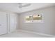 Neutral bedroom featuring two doors, light tile floors, and a window for natural light at 11055 7Th E St, Treasure Island, FL 33706