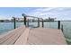 Dock view with a boat lift and bench overlooking a wide waterway lined with waterfront homes at 11055 7Th E St, Treasure Island, FL 33706