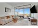 Living room with a large sectional sofa and open door to balcony showing waterfront view at 111 N 12Th St # 1707, Tampa, FL 33602