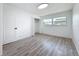Bedroom with wood-look flooring, neutral walls, a large window, and a closet at 1433 S Belcher Rd # B11, Clearwater, FL 33764