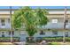 Exterior of the condo building with lush landscaping, shade tree and rock feature at 1433 S Belcher Rd # B11, Clearwater, FL 33764