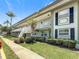 Inviting exterior of the condo building with white trim, balconies, and lush green landscaping at 1433 S Belcher Rd # B11, Clearwater, FL 33764