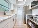 Bright kitchen with new stainless steel appliances, white cabinets, and wood-style flooring at 1433 S Belcher Rd # B11, Clearwater, FL 33764