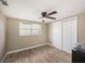 Cozy bedroom with wood-look tile, a ceiling fan, and closet space for ample storage at 15525 Old Dixie Hwy, Hudson, FL 34667